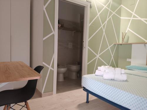 a room with a bed and a bathroom with a toilet at l'alba sullo jonio in Taranto