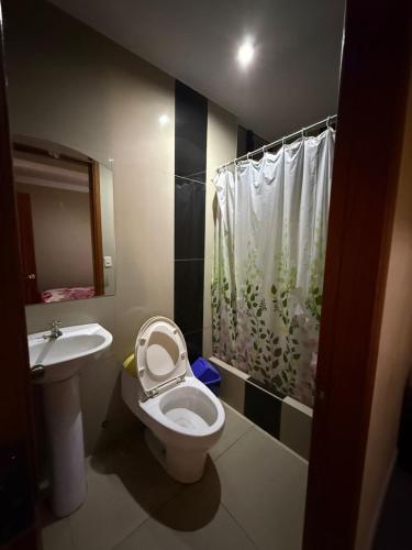 a bathroom with a toilet and a sink and a shower at Hostal Tintaya in Cajamarca