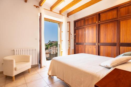 a bedroom with a bed and a chair and a window at Stunning Deià Views & Private Pool in Deia