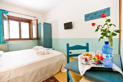 a bedroom with a bed and a table with a tray of food at History Hotel in Valderice