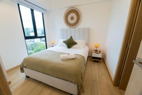 a bedroom with a bed and a large window at Apartamento Moderno z 10-Jacuzzi-Lavandería-AC-Gym-GuatemalaCity in Lo de Contreras