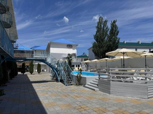 a pool with chairs and umbrellas and a staircase at Aquamarin in Zatoka