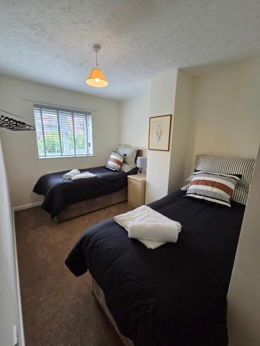 a bedroom with two beds and a window at 3 bed house in Winterbourne Abbas in Winterborne Abbas