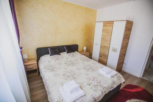 ein Schlafzimmer mit einem Bett mit einer geblümten Tagesdecke in der Unterkunft Sun View Boulevard in Alba Iulia