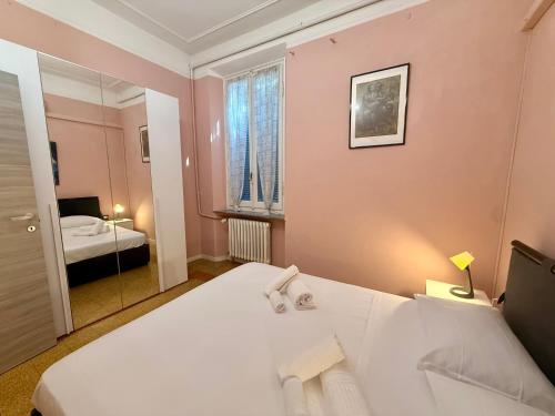a bedroom with a large white bed and a mirror at La Gardenia del ducato in Parma