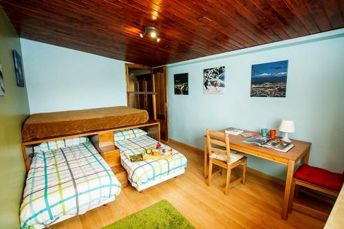 ein Schlafzimmer mit zwei Etagenbetten und einem Schreibtisch in der Unterkunft Sierra Nevada Home in Sierra Nevada