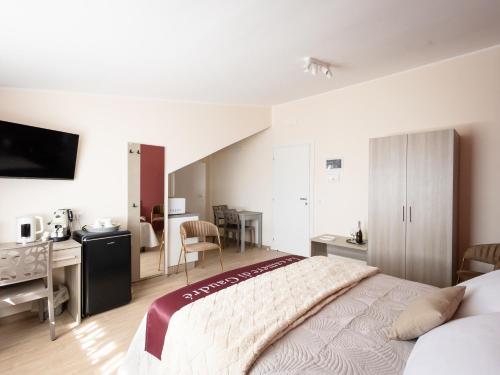 a bedroom with a bed and a desk and a kitchen at Le camere di Gaudré in Battipaglia