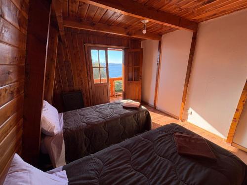 a bedroom with two beds in a room with a window at Olly Patagonia Suites in San Carlos de Bariloche