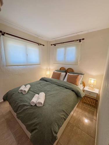 a bedroom with a bed with two towels on it at Plagia Oasis Escape in Nea Plagia