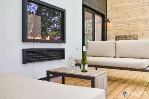 a living room with a couch and a table at Chalet Altitude Riverfront Pet-Friendly in Saint-Raymond