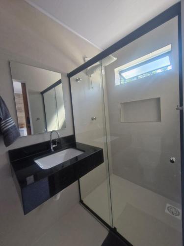 a bathroom with a sink and a glass shower at Loft da Árvore in Petrópolis
