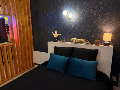 a bedroom with a bed with blue pillows on it at Spa des Sacres - Suite avec Jacuzzi Privatif in Reims
