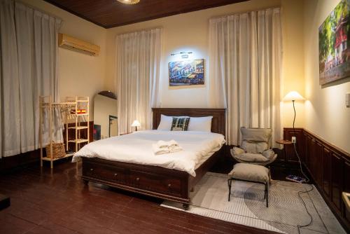 a bedroom with a bed and a chair at DoDo Apartments in Hanoi