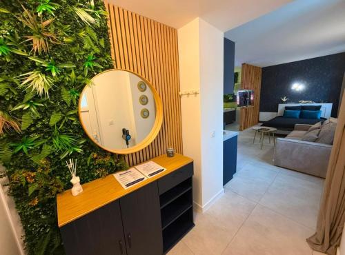 a bathroom with a mirror on a wall at Spa des Sacres - Suite avec Jacuzzi Privatif in Reims