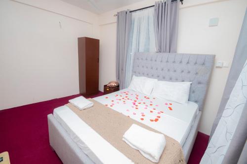a bedroom with a large white bed with flowers on it at Zanzibar Rahaa in Dar es Salaam