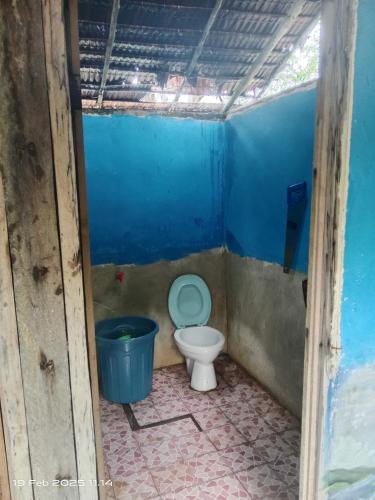 a small bathroom with a toilet and a bucket at Lagoon Homestay in Keruo