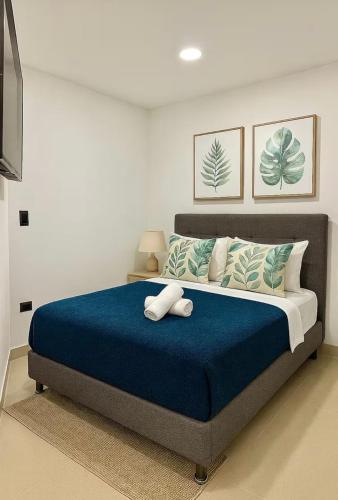a bedroom with a large bed with a blue blanket at Apartamento Tranquilo y Acogedor in Sabaneta