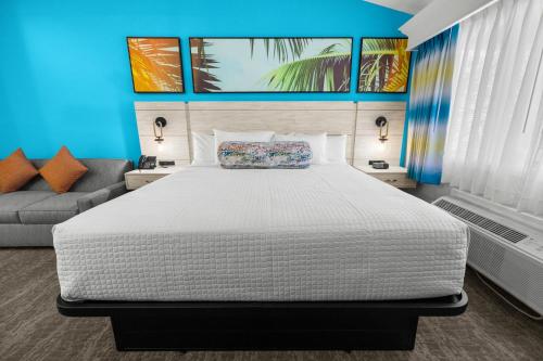 a bedroom with a large white bed and a couch at Grand Palms Resort in Myrtle Beach