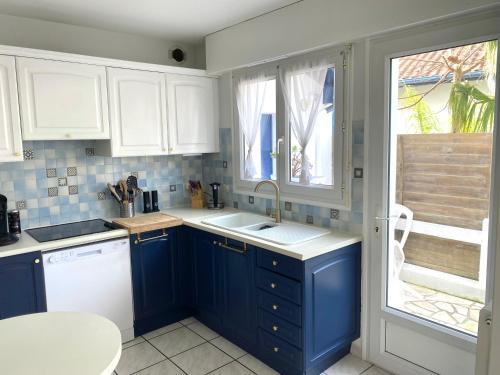 a kitchen with blue cabinets and a sink and a window at Agréable Maison basque-Anglet in Anglet