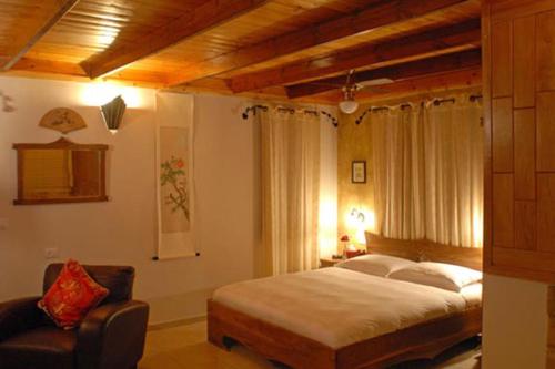 a bedroom with a bed and a chair at בקתות באהבה בוטיק in Rosh Pinna