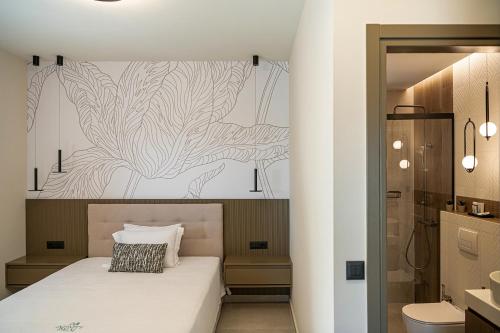 a bedroom with a white bed and a bathroom at Infinity Palm Villa in Stavros