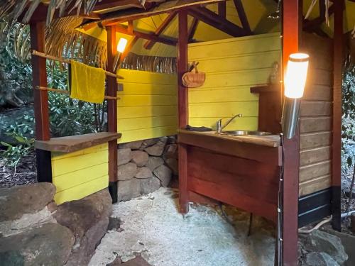 a bathroom in a house with a sink at Hutte Karaib Reve de Robinson Une cabane perchee au cœur de la nature tropicale vue mer in Terre-de-Bas