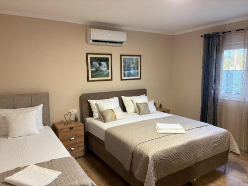 a bedroom with two beds and a air conditioner at Villa Vukas in Mostar