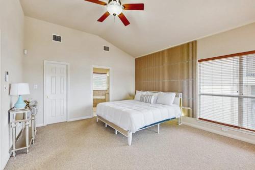 a bedroom with a white bed and a ceiling fan at Scenic Riverfront Home with Boat Access, Private Pool/Hot Tub - Close to Shopping in Lago Vista