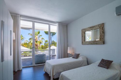 a hotel room with two beds and a balcony at Can Love in Cala Comte