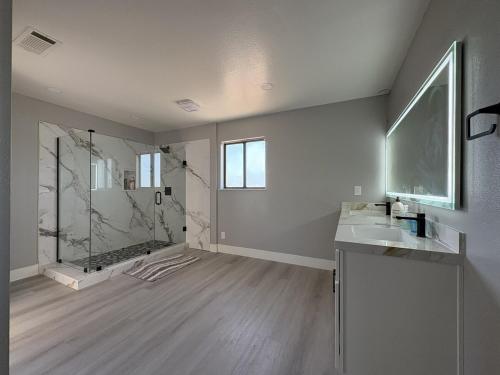 a bathroom with a shower and a sink and a mirror at Vintage Vineyard Estate in Oakley