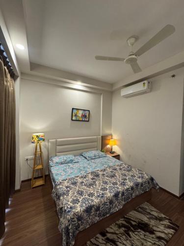 a bedroom with a bed and a ceiling fan at the Aurelia estate studio apartment Alpha 2 in Greater Noida
