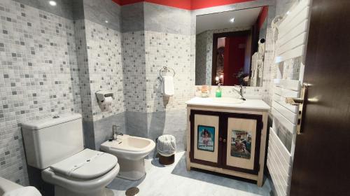 a bathroom with a white toilet and a sink and a toilet istg at Casona El Gurugu in Luarca