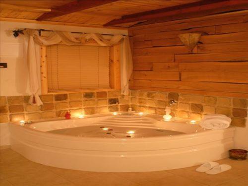 a bathroom with a tub with lights in it at בקתות באהבה בוטיק in Rosh Pinna