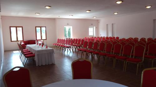 una habitación con sillas y mesas rojas en Lagou Raxi Country Hotel, en Lavkos