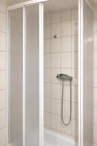 a shower with a glass door in a bathroom at APARTMENT ON THE ROAD S-61 in Szypliszki