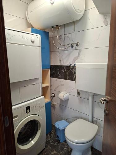 a bathroom with a washing machine and a toilet at Kameni biser in Jurdani