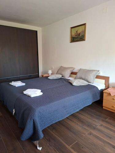 a bedroom with a large bed with a blue blanket at Kameni biser in Jurdani