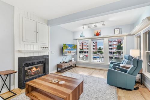 a living room with a fireplace and a blue chair at SBC1001 - Sweet Retreat in Manteo