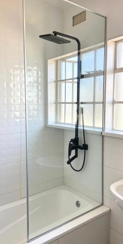 a glass shower in a bathroom with a sink at 2 Bed Cottage close to Westgate Shopping Centre in Harare