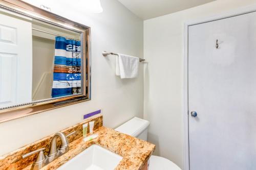 a bathroom with a sink and a mirror and a toilet at Charming, lakefront A-frame with private dock, lakeside gazebo, spacious deck in Bumpass