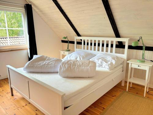 a white bed with pillows on it in a room at Villa Yasjö in Eringsboda