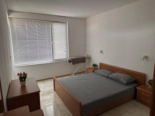 a bedroom with a bed and a large window at Апартамент Енигма in Sveti Vlas