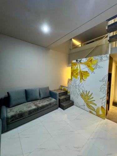 a living room with a couch and a mural at Comfortable House - Tabebuya BSD in Tegal