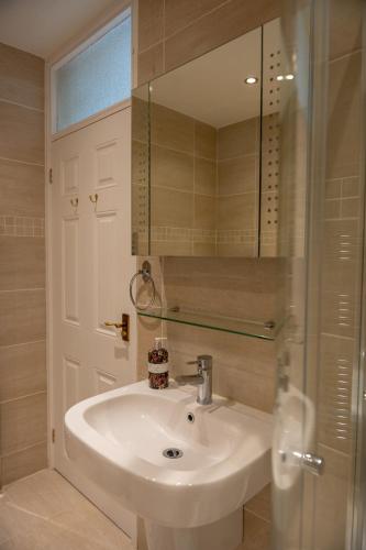 a bathroom with a white sink and a mirror at Aughamore Home in CBG
