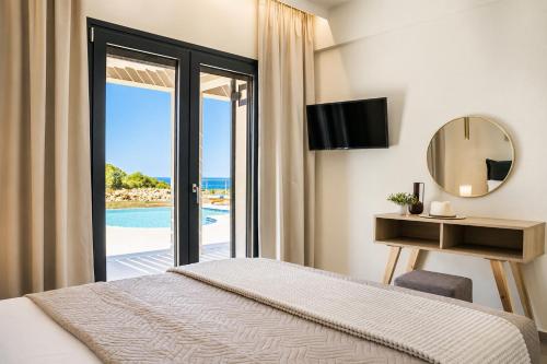 a bedroom with a bed and a view of the ocean at Villa Pinelopi Tria in Kounopetra