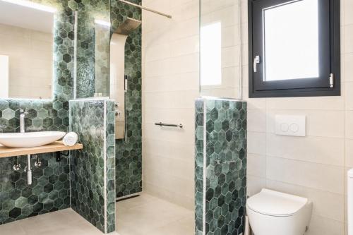 a bathroom with a shower and a toilet and a sink at Villa Pinelopi Tria in Kounopetra