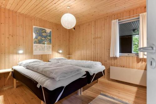 a bedroom with a large bed in a wooden room at BV310-Blavand-Gronnevej-16 in Blåvand