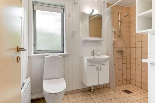 a bathroom with a toilet and a sink and a window at BV310-Blavand-Gronnevej-16 in Blåvand