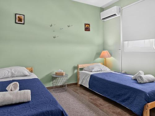 two beds in a room with blue sheets at Rest Studio 6 in Sotira