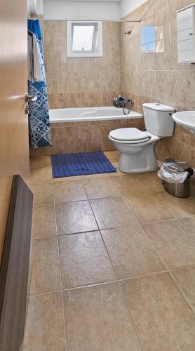 a bathroom with a toilet and a tub and a sink at Rest Studio 6 in Sotira